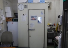 神奈川県逗子市の寿司店厨房に新設されたプレハブ冷蔵庫。限られた作業スペースに効率的に設置され、周囲には流し台や事務設備も共存している
