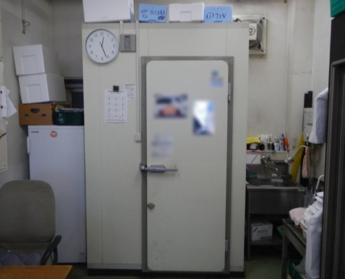 神奈川県逗子市の寿司店厨房に新設されたプレハブ冷蔵庫。限られた作業スペースに効率的に設置され、周囲には流し台や事務設備も共存している