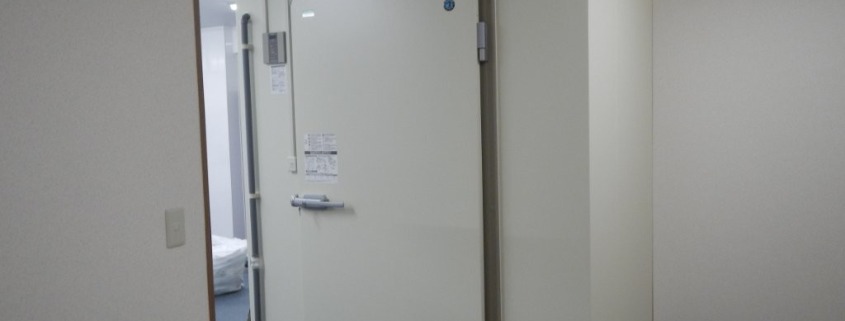 介護施設の厨房内に新設されたプレハブ冷蔵庫の外観。断熱パネル仕様で高気密設計の業務用冷蔵庫